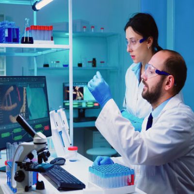 Chemist nurse holding test tubes bringing to doctor conducting DNA experiment discussing about medical treatment working overtime. Stuff examining virus evolution using high tech researching diagnosis
